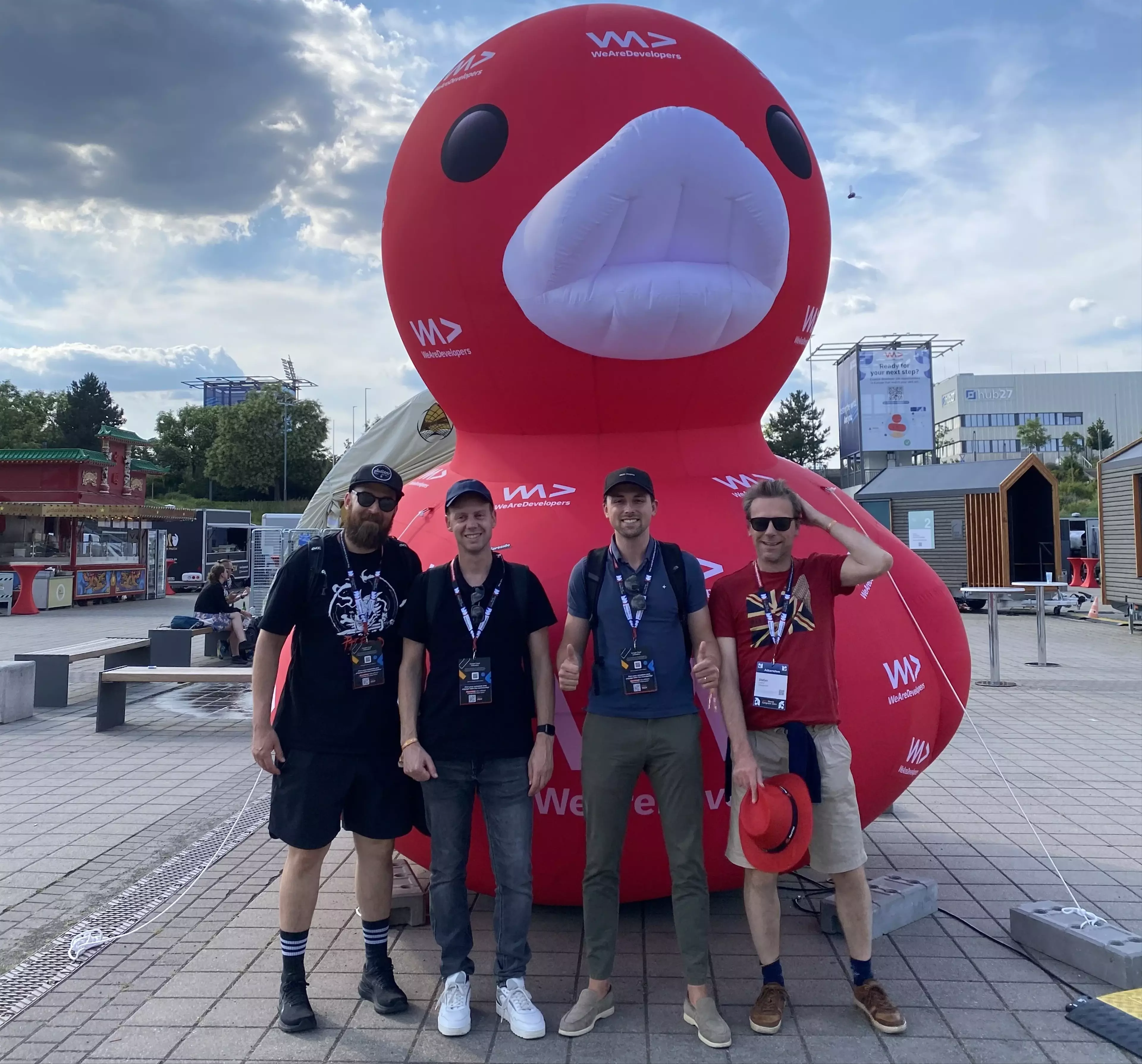 Posing with a group of four colleagues in front of the WeAreDevelopers mascot, a large rubber duck.